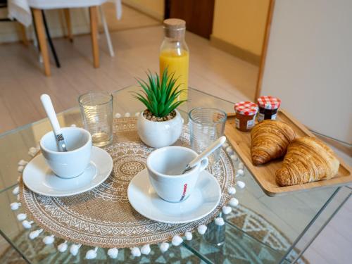 a table with coffee cups and croissants on it at Studio Studio des Halles by Interhome in Pornic