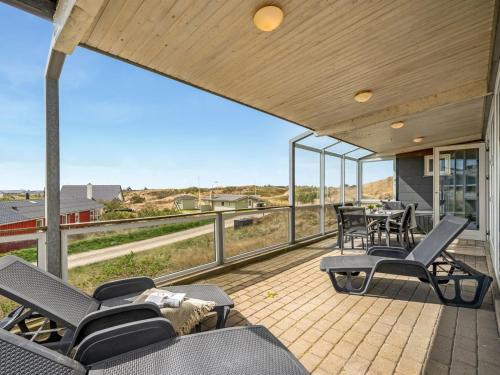 un patio con sillas y una mesa con vistas en Holiday Home Emelin - 475m from the sea in Western Jutland by Interhome, en Ringkøbing