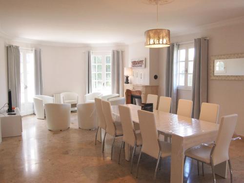a dining room with a table and white chairs at Holiday Home La Villa by Interhome in Saint-Jouan-des-Guérets