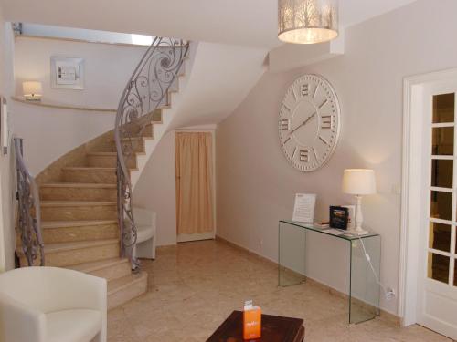 Zimmer mit einer Treppe und einer Uhr an der Wand in der Unterkunft Holiday Home La Malouinière des Longchamps by Interhome in Saint-Jouan-des-Guérets