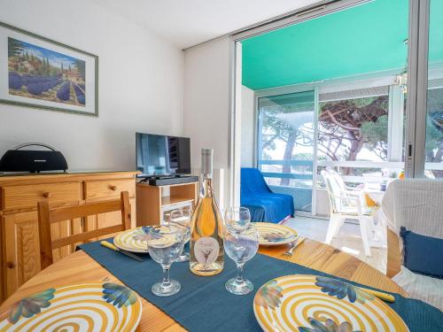 une table de salle à manger avec des assiettes et des verres dessus dans l'établissement Apartment Bateau Blanc by Interhome, à Hyères