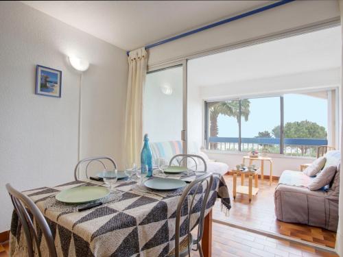 une salle à manger avec une table et une vue sur l'océan dans l'établissement Apartment Mykonos-3 by Interhome, à Port-Leucate
