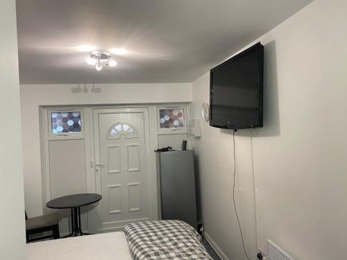 a bedroom with a bed and a flat screen tv at Guest House in Milton Keynes in Milton Keynes