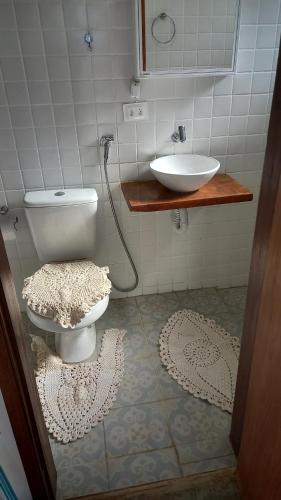 a bathroom with a toilet and a sink at Chalé doce beija-flor in Campos do Jordão