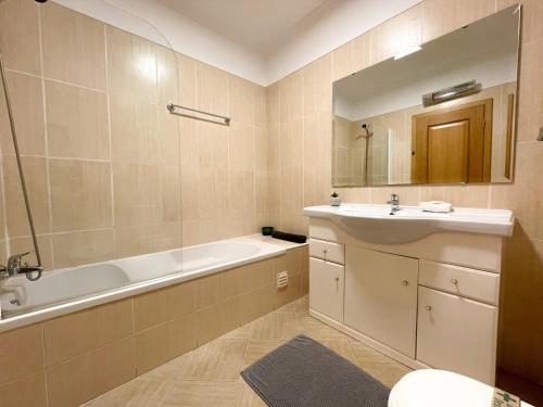 La salle de bains est pourvue d'une baignoire, d'un lavabo et d'une baignoire. dans l'établissement Oura Lancemar by Sunny Deluxe, à Albufeira