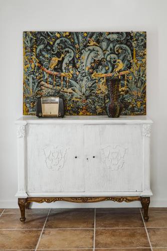 a white dresser in a room with a painting on the wall at 3-Room, 3-Bath Villa with Massive Pool, Central Location, Seconds from Cliff! in Imerovigli