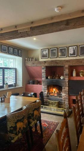 a living room with a fireplace and a table and chairs at The Swan at Tarporley in Tarporley