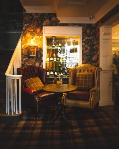 a room with a table and a couch and wine bottles at The Swan at Tarporley in Tarporley