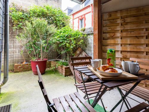 - une table avec un bol de nourriture sur la terrasse dans l'établissement Holiday Home L'Aguesseau by Interhome, à Trouville-sur-Mer