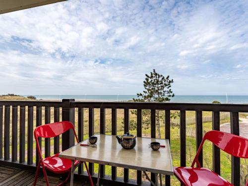- une table et des chaises sur une terrasse avec vue sur l'océan dans l'établissement Apartment Cabourg Plage-19 by Interhome, à Cabourg