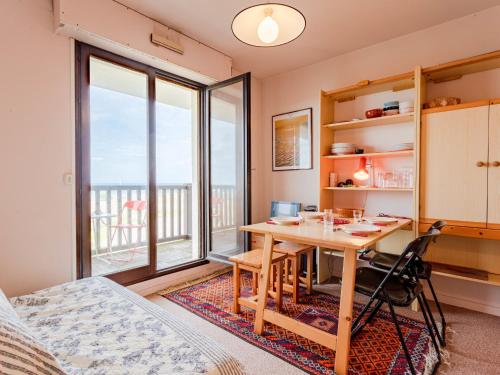 une salle à manger avec une table et une vue sur l'océan dans l'établissement Apartment Cabourg Plage-19 by Interhome, à Cabourg