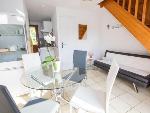 a living room with a glass table and white chairs at Apartment Le Renard by Interhome in Saint-Jouan-des-Guérets