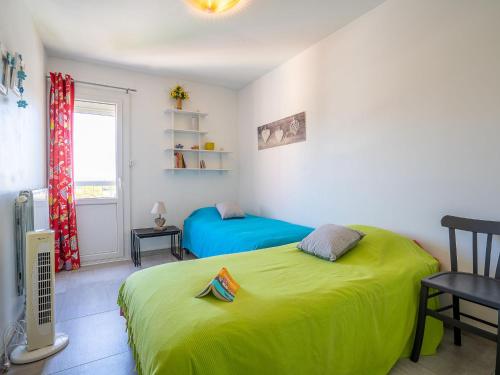 une chambre avec un lit vert et une fenêtre dans l'établissement Apartment Les Roches Bleues-2 by Interhome, au Pradet