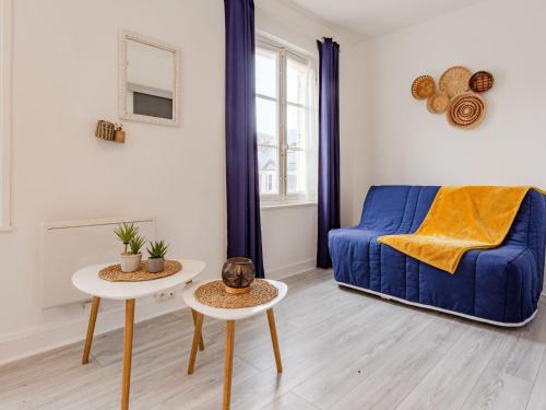 een woonkamer met een blauwe bank en 2 tafels bij Studio La Batelière by Interhome in Trouville-sur-Mer