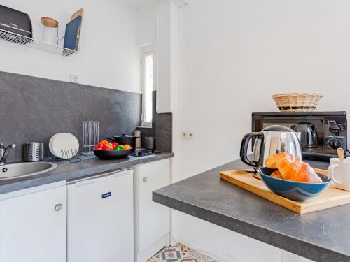 um balcão de cozinha com uma tigela de fruta numa tábua de cortar em Studio La Batelière by Interhome em Trouville-sur-Mer