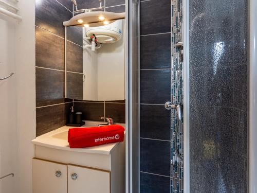 une salle de bain avec une douche et un sac rouge sur un lavabo dans l'établissement Studio La Batelière by Interhome, à Trouville-sur-Mer