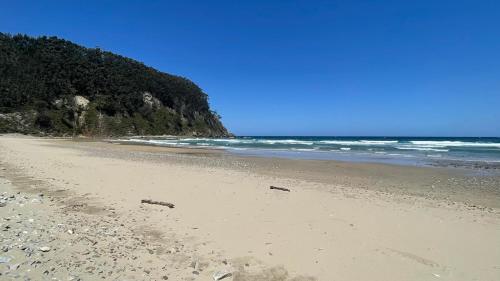 a sandy beach with rocks and the ocean at Apartamentos ELROSAL2 in Cudillero