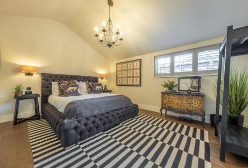 a bedroom with a large bed and a chandelier at The Haybarn in Cranleigh