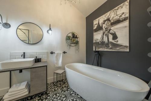 a bathroom with a large white tub and a sink at The Haybarn in Cranleigh