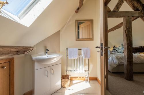 a bathroom with a sink and a bed at The Garden Barn in Peterchurch