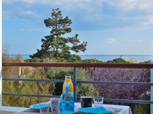 een tafel met een fles op een balkon met uitzicht bij Apartment Charme de Villès Martin by Interhome in Saint-Nazaire