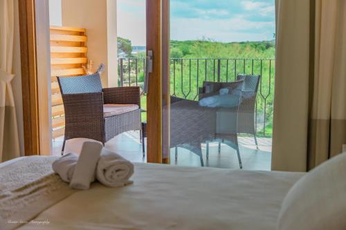 a bedroom with a bed with a view of a balcony at Stella Marina Budoni in Budoni
