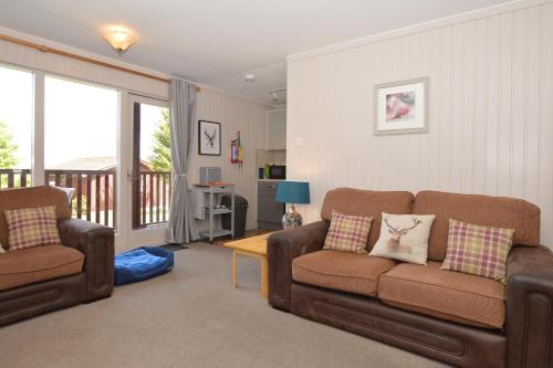 a living room with two chairs and a couch at Blairlagan Lodge in Hunters Quay