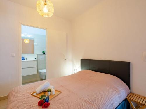 a bedroom with a bed with a tray of food on it at Apartment Le Cyrnos by Interhome in Saint-Aygulf