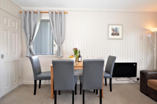 a dining room with a table and chairs at Blairlagan Lodge in Hunters Quay