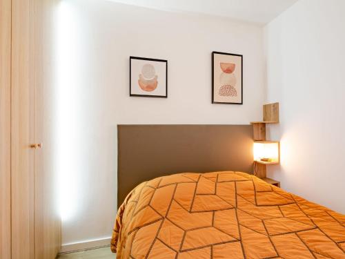 une chambre avec un lit et deux tableaux au mur dans l'établissement Apartment Régina-14 by Interhome, à Sainte-Maxime