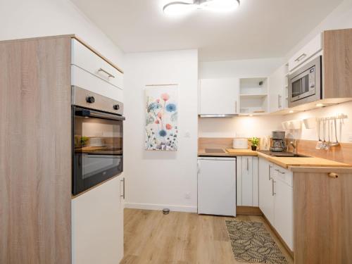 une cuisine avec des appareils électroménagers blancs et des armoires en bois dans l'établissement Apartment Régina-14 by Interhome, à Sainte-Maxime