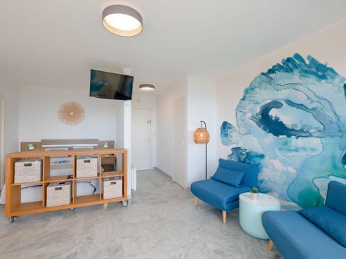 un salon avec un canapé bleu et une télévision dans l'établissement Studio Résidence Les Gemeaux by Interhome, à Saint-Raphaël