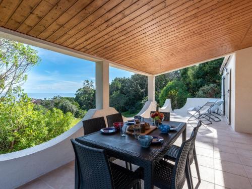 a table and chairs on a patio with a view at Holiday Home Villa Bruzzi by Interhome in Pianottoli-Caldarello