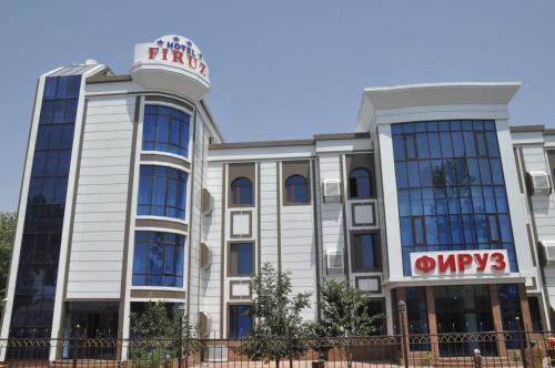 a building with a sign on top of it at Firuz Hotel in Khujand