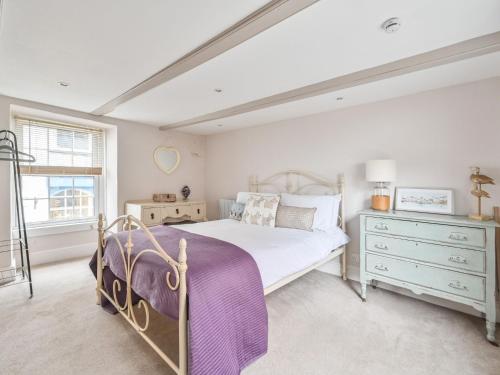 a bedroom with a bed and a dresser and a window at Holiday Home Mariners Rest by Interhome in Mevagissey