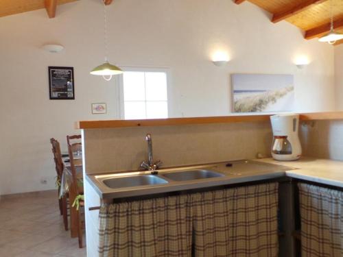 una cucina con un lavello e un piano di lavoro di Maison lumineuse avec jardin clos, à 400m de la plage, pour 8 personnes, secteur calme - FR-1-224B-22 a LʼÉpine