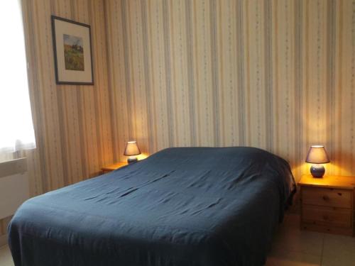 una camera con un letto e due comodini con due lampade di Maison lumineuse avec jardin clos, à 400m de la plage, pour 8 personnes, secteur calme - FR-1-224B-22 a LʼÉpine
