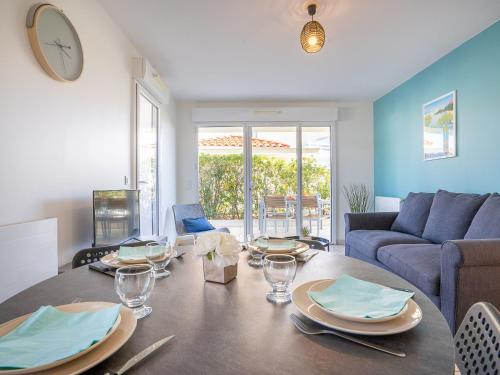 een eetkamer met een tafel en een bank bij Apartment Royal Rivage-3 by Interhome in Carqueiranne