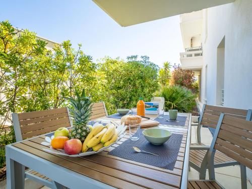 - une table en bois avec une assiette de fruits dans l'établissement Apartment Royal Rivage-3 by Interhome, à Carqueiranne