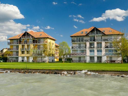 ein Resort mit zwei Gebäuden neben einem Wasserkörper in der Unterkunft Apartment Olivia by Interhome in Balatonőszöd