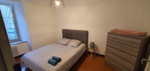 um pequeno quarto com uma cama e uma cómoda em Charmant appartement en centre-ville 70m2 em Digne-Les-Bains