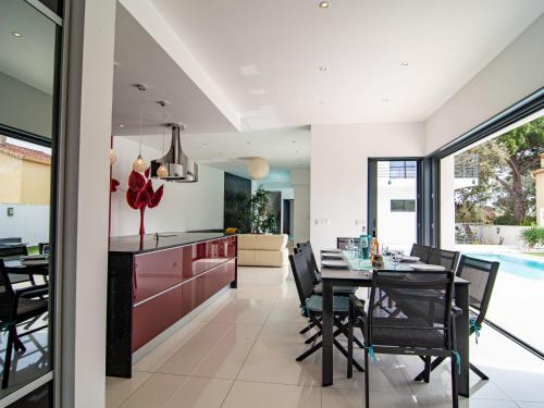 une cuisine et une salle à manger avec une table et des chaises dans l'établissement Holiday Home L'Oustaloun by Interhome, à Saint-Aygulf