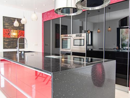 a kitchen with black countertops and pink walls at Holiday Home L'Oustaloun by Interhome in Saint-Aygulf