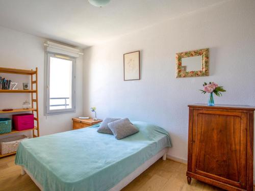 une chambre avec un lit et une commode en bois dans l'établissement Apartment Le Lagon Bleu by Interhome, à Cagnes-sur-Mer