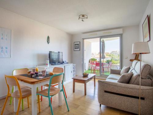 un salon avec un canapé et une table avec des chaises dans l'établissement Apartment Le Lagon Bleu by Interhome, à Cagnes-sur-Mer