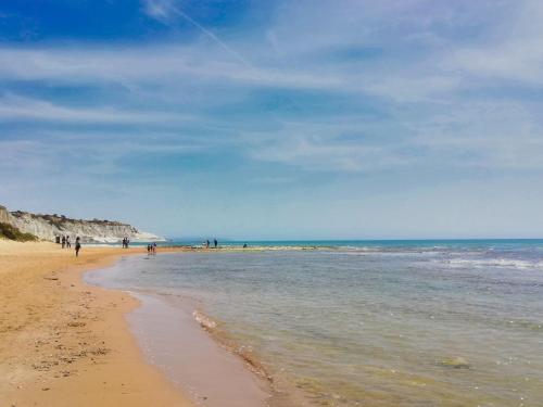 a beach with people flying a kite on it at Villa Orizzonte Holidays by Interhome in Realmonte