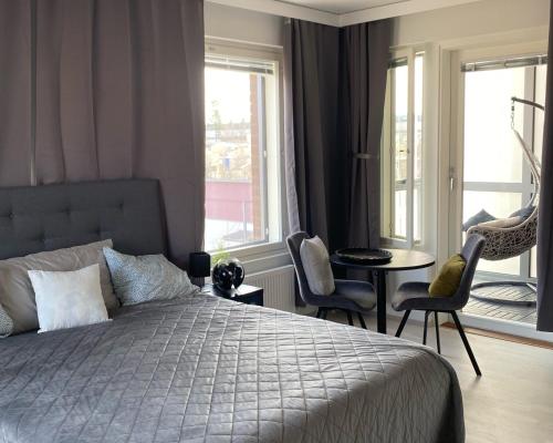 a bedroom with a bed and a table and chairs at BOSSHOMES Apartments Espoo - Close to Helsinki and access to Airport in Espoo