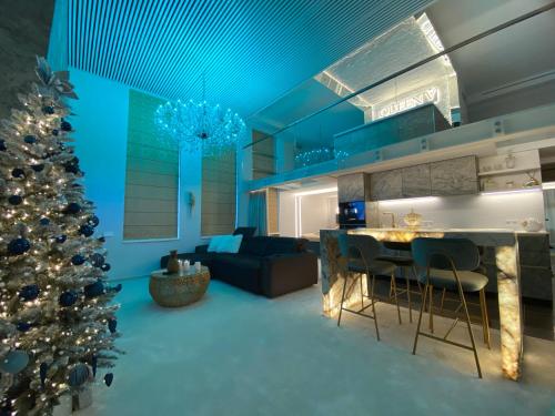 a living room with a christmas tree and a couch at Luxury Queen V apartment with Jacuzzi in Kaunas