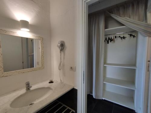 SUITE Rooms in Tenuta Asinara Vineyard في سورسو: حمام مع حوض ومرآة