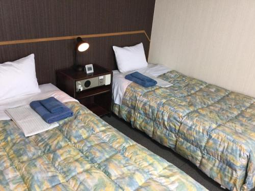 two beds sitting next to each other in a room at Palude Kushiro in Kushiro